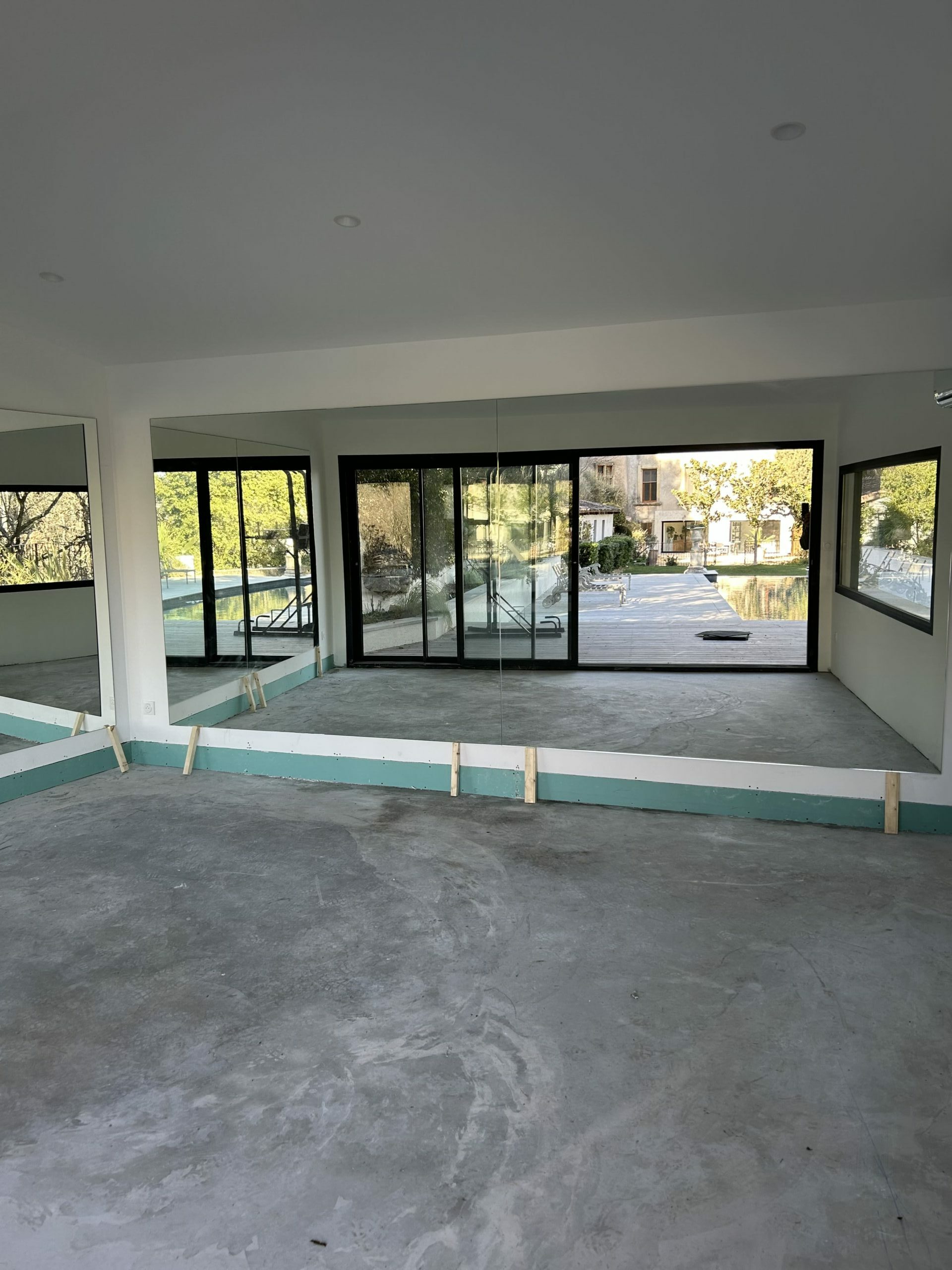 Pose de miroirs pour une salle de sport privée à Célony